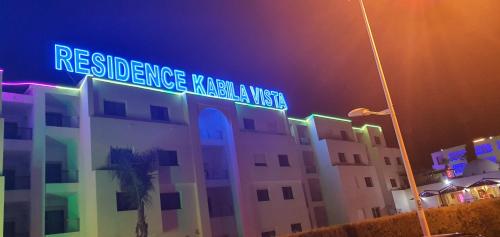 un panneau indiquant la rue au-dessus d'un bâtiment la nuit dans l'établissement KABILA VISTA n3, à M'diq