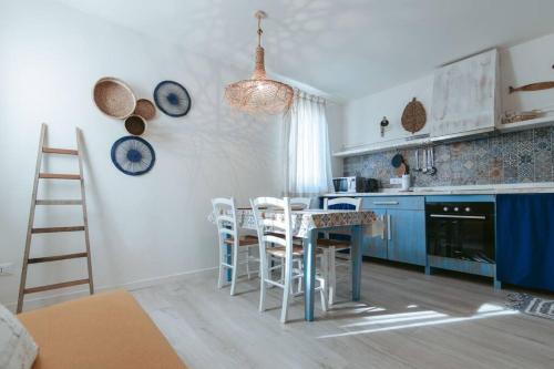 une cuisine avec des armoires bleues, une table et des chaises dans l'établissement Alessandro’s Home, à Chioggia
