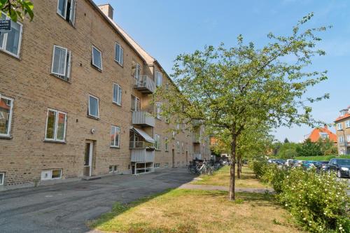 ein Baum vor einem Backsteingebäude in der Unterkunft Modern Central Located Apartment in Kopenhagen