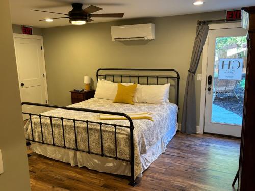 a bedroom with a bed with yellow pillows at Hermann Crown Suites in Hermann