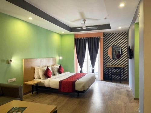 a bedroom with a bed with green walls at Hotel Rudra Inn At Chattarpur in New Delhi