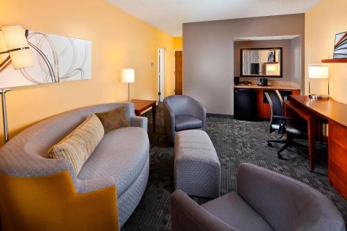 a hotel room with a couch and a desk at Courtyard Miami Airport West/Doral in Miami