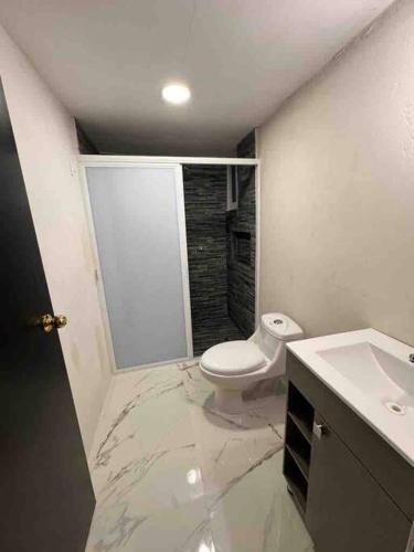 a bathroom with a toilet and a sink at Apartamento confortable y bien ubicado in Santa Cruz Huatulco