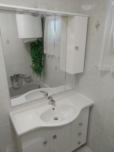 a white bathroom with a sink and a mirror at Üttörő út 177 B in Balatonfenyves