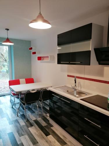 a kitchen with a sink and a table with chairs at Ferienwohnung I Sarrebriese in Bottmersdorf