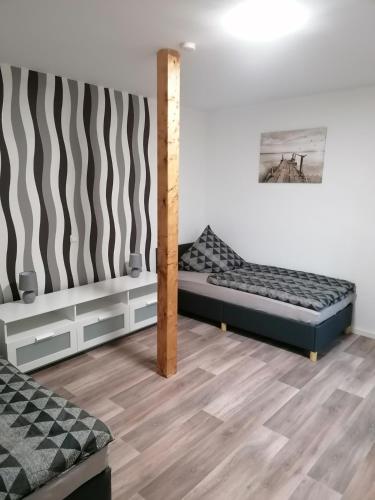 two beds in a room with wooden floors at Ferienwohnung I Sarrebriese in Bottmersdorf