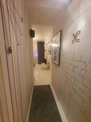 a hallway with a bathroom with writing on the wall at Romana Studio in Bucharest