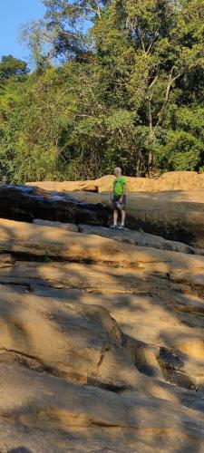 a boy is sitting on some rocks at Munnar Village Homes in Munnar