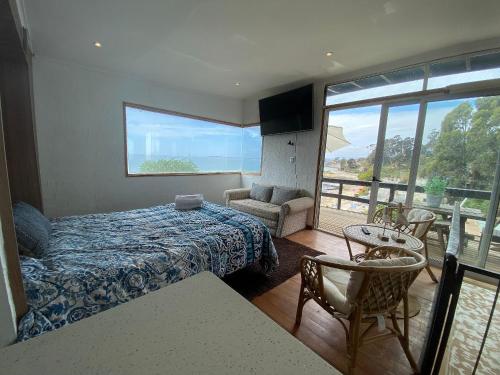 um quarto com uma cama e vista para o oceano em Hermosa Cabaña Rustica en Playa Negra em Concón
