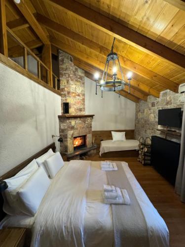 a bedroom with a large bed and a fireplace at Hotel Ambassador Voskopojë in Voskopojë