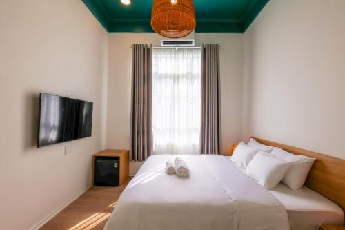 a bedroom with a bed and a window with shoes on it at Lemi - Homestay in Hue in Hue