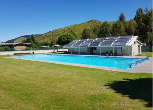 a large swimming pool with a building with solar panels at The Church Millers Flat in Millers Flat