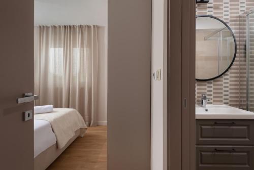 ein Badezimmer mit Waschbecken und Spiegel in der Unterkunft Villa Bellatrix 1 & 2 - two heated pools & jacuzzi in Vrsi