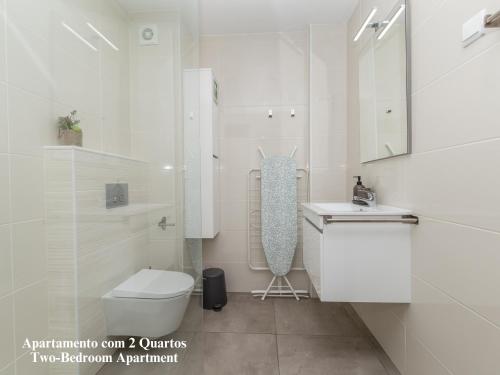 ein weißes Bad mit einem WC und einem Waschbecken in der Unterkunft Akisol Albufeira Breezy in Olhos de Água