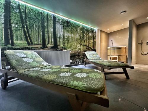 Cette chambre comprend deux bancs et un mur orné d'une fresque murale représentant la forêt. dans l'établissement Apartament Pod Wyciągiem - Czarna Góra Resort & SPA, à Sienna