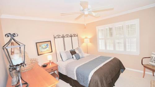 une chambre avec un lit et un ventilateur de plafond dans l'établissement 3 Palms West, à Gulf Shores