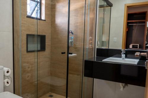 a bathroom with a shower and a sink at Adria Premium Hotel in Guarapuava