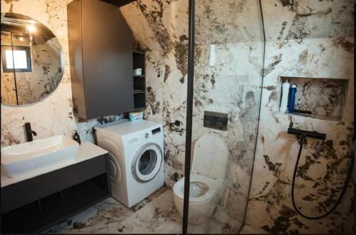 a bathroom with a toilet and a sink and a washing machine at Sirius Lux Apartmani in Žabljak