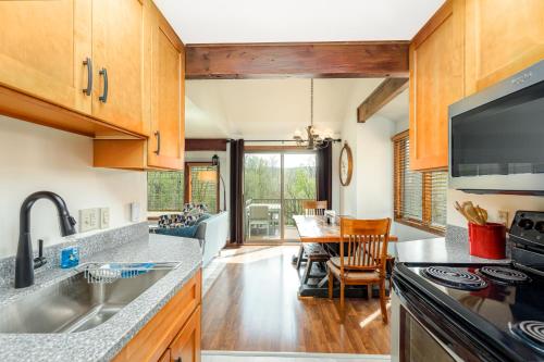 a kitchen with wooden cabinets and a dining room at Quiet Home Minutes from Lake Galena & Eagle Ridge in Galena