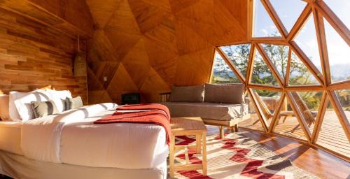 a room with a bed and a couch in a room at Estancia Patagonia El Calafate - Pristine Luxury Camps in El Calafate