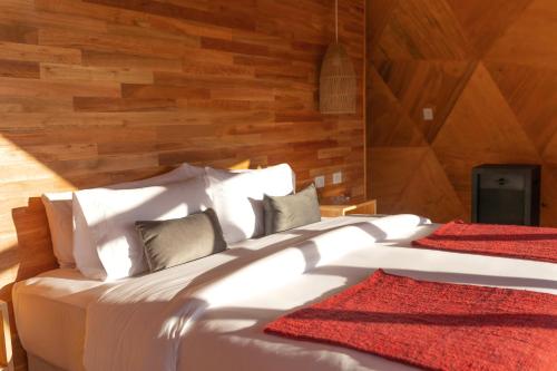 sypialnia z 2 białymi łóżkami i drewnianymi ścianami w obiekcie Estancia Patagonia El Calafate - Pristine Luxury Camps w mieście El Calafate