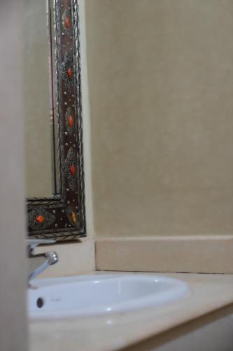 Eden Palm Resident Palmeraie Marrakech في مراكش: حمام مع مرآة ومغسلة