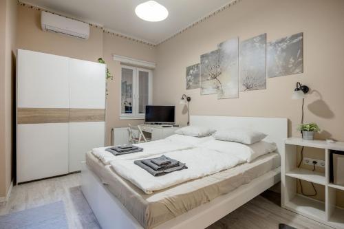 a white bedroom with a bed and a desk at RoomBack Rooms - 2BR Apt with AC near Deak ter in Budapest