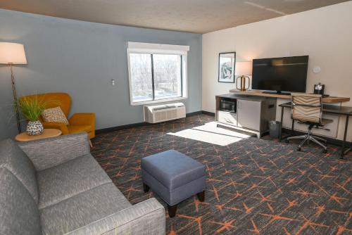 a living room with a couch and a tv at Holiday Inn Cleveland-Mayfield by IHG in Mayfield