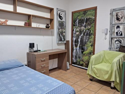 1 dormitorio con cama, escritorio y ventana en Prático e bem localizado Studio, na CB en Porto Alegre