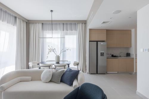 a living room with a white couch and a table at Creek Beach Roomy 3BR + terrace in Dubai