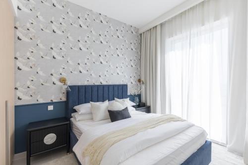a bedroom with a blue and white wall with birds on it at Creek Beach Roomy 3BR + terrace in Dubai