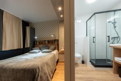 une chambre avec un grand lit et une salle de bain dans l'établissement Appart. 4 couchages 3 étoiles - Accès télécabine, à Saint-Lary-Soulan