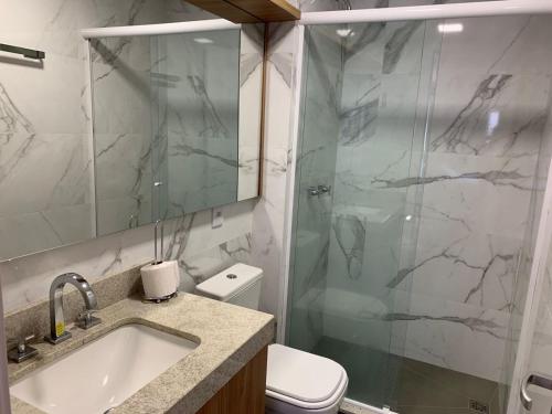 een badkamer met een douche, een wastafel en een toilet bij Liv - Apartamento 803 in Porto Alegre