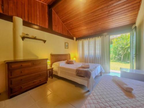a bedroom with two beds and a wooden ceiling at Casa em Geribá in Búzios