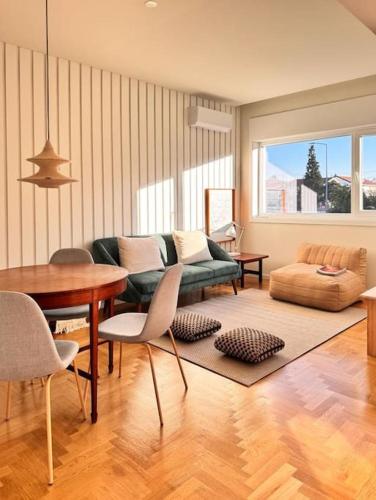 a living room with a green couch and a table at Porto Aldoar Boutique Flat Garden -Duarte in Porto