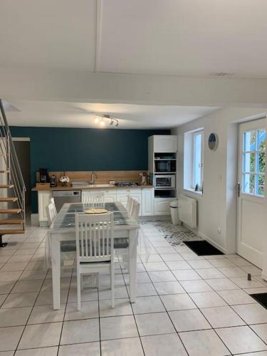 une cuisine avec une table et des chaises dans une pièce dans l'établissement Les Falaises d'Albâtre, à Heuqueville
