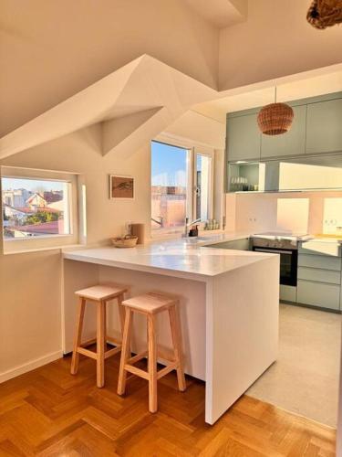 a kitchen with a large counter with two stools at Porto Aldoar Boutique Flat Garden -Duarte in Porto