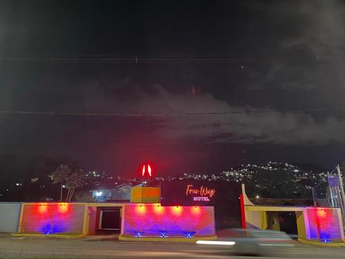 a building with colorful lights on it at night at Free Way Motel in Poços de Caldas