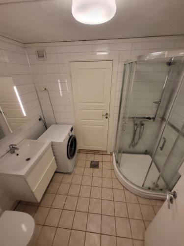 een badkamer met een douche, een wastafel en een achterdeur met een douche bij 4 Bedrooms, 9 Guest Apartment in Kjeller Lillestrøm - Good proximity to OSLOMET and Lillestrøm Train Station in Lillestrøm