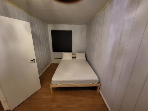 een kleine kamer met een bed en een flatscreen-tv bij 4 Bedrooms, 9 Guest Apartment in Kjeller Lillestrøm - Good proximity to OSLOMET and Lillestrøm Train Station in Lillestrøm