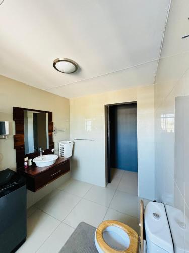 a bathroom with a toilet and a sink and a mirror at 2BR Apartment near Etosha in Katutura