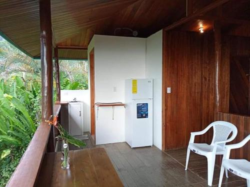 een keuken met een koelkast, een tafel en een stoel bij Casa Miramar in Uvita