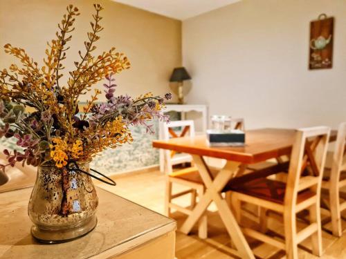 a vase with flowers on a table in a room at Depto. Pucón in San Cristóbal de Las Casas