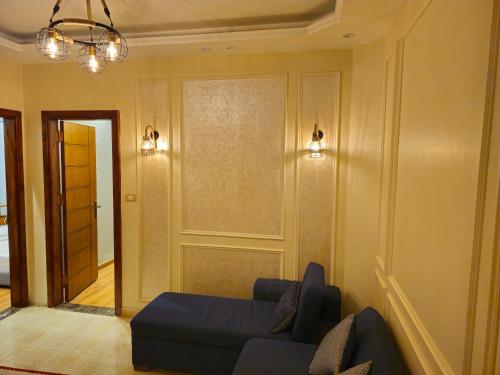 a living room with a blue couch and lights at 3rd floor luxury apartment-families only in Alexandria