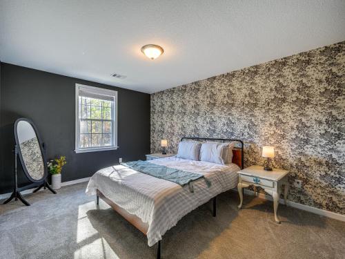 a bedroom with a large bed and a wall with floral wallpaper at Spacious Columbus Getaway with Patio - Pets Welcome! in Columbus