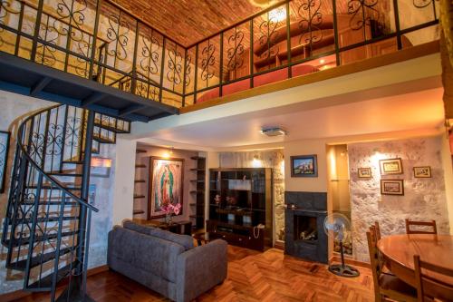 a living room with a staircase and a fireplace at Hotel Casona Solar in Arequipa