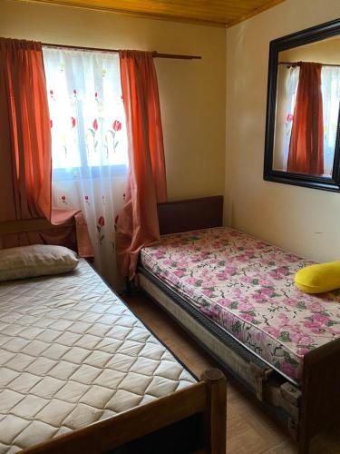 1 dormitorio con 2 camas y ventana en Casa Mía Blue 2, en Chillán