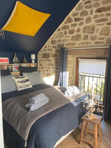 a bedroom with a large bed and a stone wall at Gîtes d'Izel n°2 in Ploemel