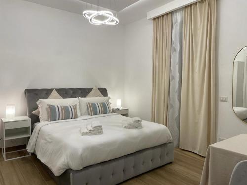 a white bedroom with a large bed and a mirror at DreamHouse Circeo in Borgo Montenero