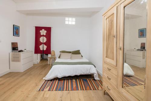 une chambre avec un lit et un grand miroir dans l'établissement L'écluse St-Pierre, à Toulouse